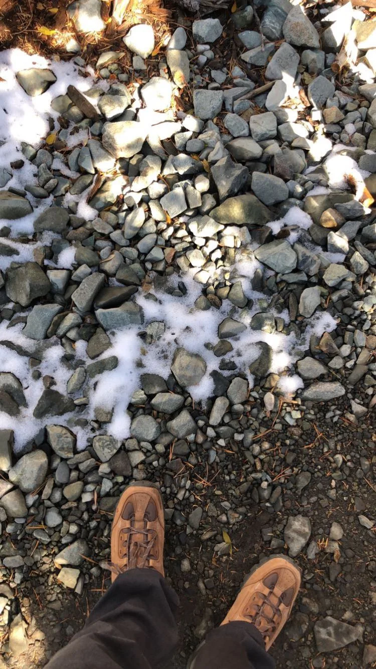 Walking over a rocky trail with patches of snow